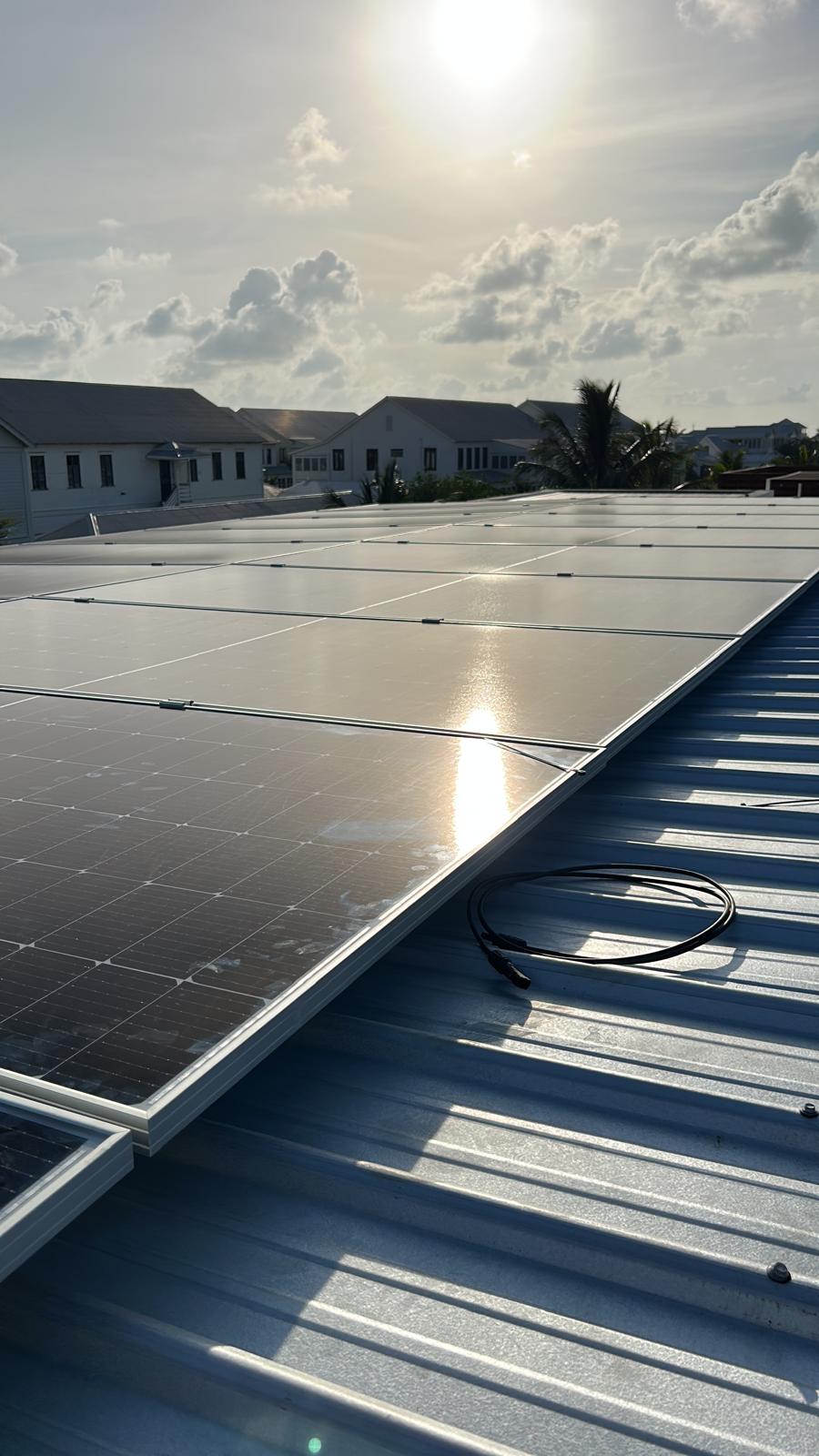 Greentech solar panels installed on a metal rooftop in Belize at sunset